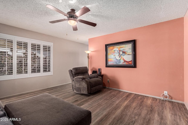 living area featuring ceiling fan, hardwood / wood-style floors, and a textured ceiling