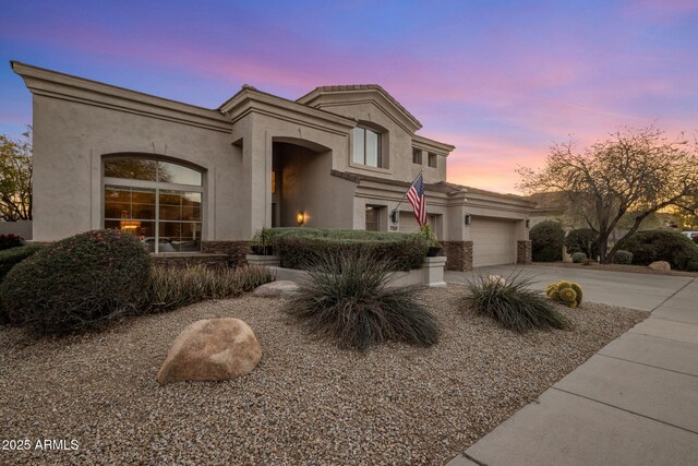 view of front of home with concrete driveway, a garage, and stucco siding