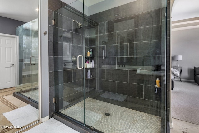 ensuite bathroom with tile patterned floors, baseboards, a stall shower, and connected bathroom