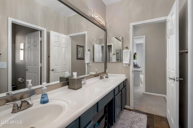 full bath featuring double vanity, baseboards, and a sink