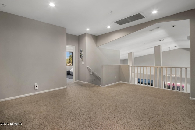 spare room with visible vents, recessed lighting, carpet floors, baseboards, and vaulted ceiling