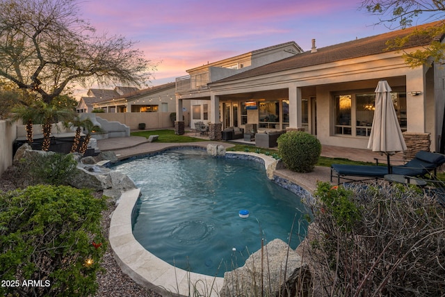 pool at dusk featuring a fenced in pool, an outdoor hangout area, a fenced backyard, and a patio area
