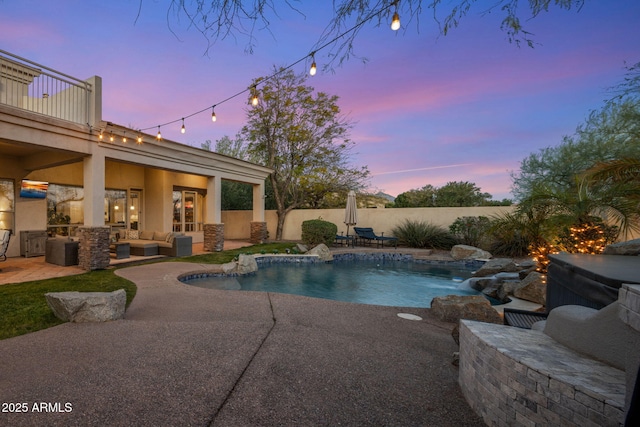 pool at dusk featuring a patio area, a fenced in pool, an outdoor hangout area, and fence
