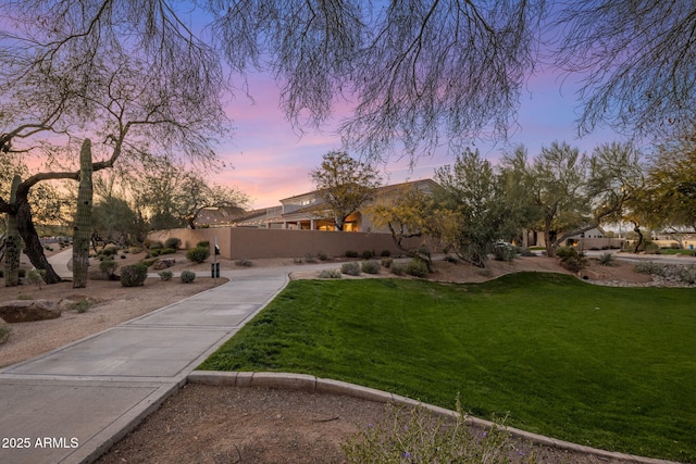 view of front of home with a yard, stucco siding, and fence
