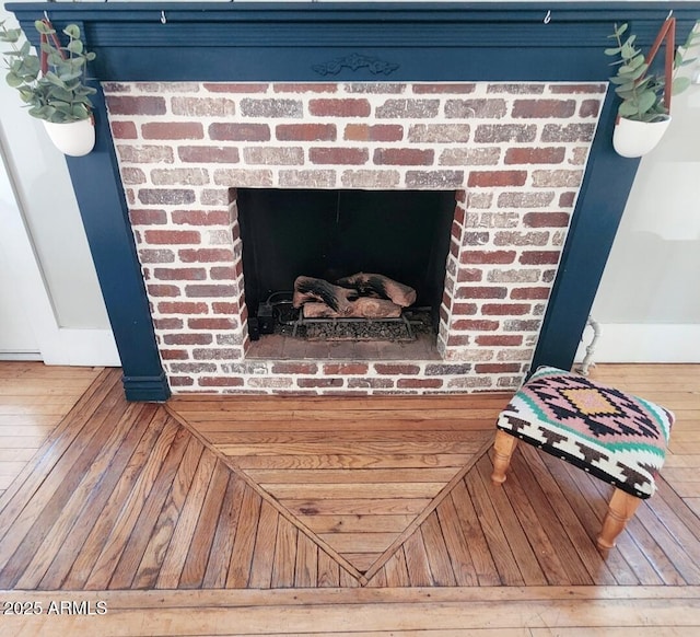 interior details with a brick fireplace and wood finished floors