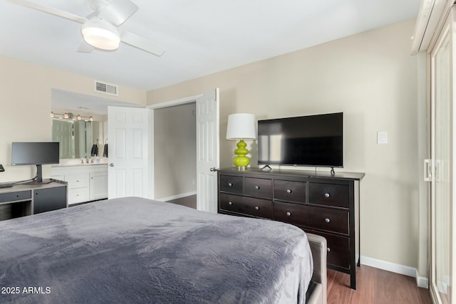 bedroom with a ceiling fan, visible vents, baseboards, dark wood-style floors, and ensuite bath