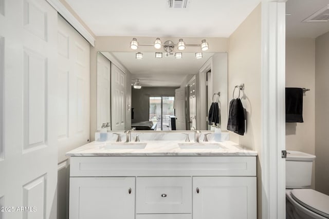 ensuite bathroom with double vanity, ensuite bath, visible vents, and a sink