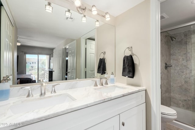 bathroom with double vanity, a stall shower, a sink, and connected bathroom