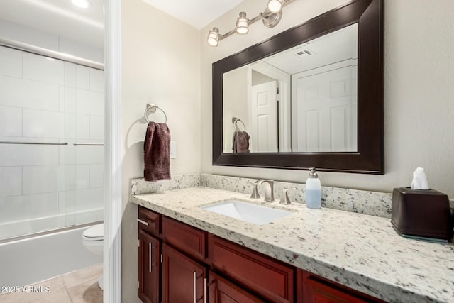 full bathroom featuring tile patterned flooring, toilet, bath / shower combo with glass door, visible vents, and vanity