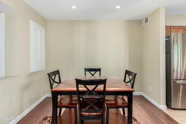 dining room featuring light wood-style floors, baseboards, and visible vents