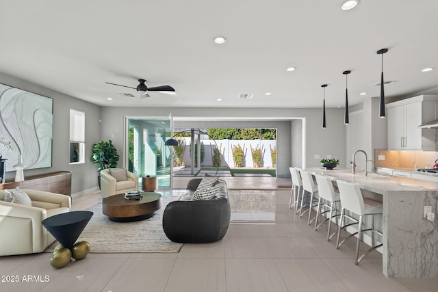 living room with ceiling fan and sink