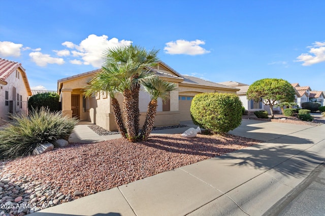 obstructed view of property with a garage, concrete driveway, and stucco siding