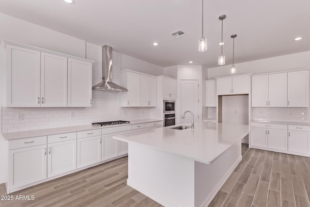 20274 W Monterey Way, Buckeye, AZ 85396 - kitchen featuring wall chimney range hood, appliances with stainless steel finishes, decorative backsplash, white cabinetry, and recessed lighting