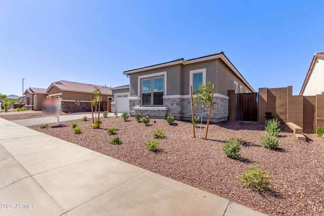 20274 W Monterey Way, Buckeye, AZ 85396 - view of front of property featuring stucco siding, a garage, a gate, concrete driveway, and stone siding