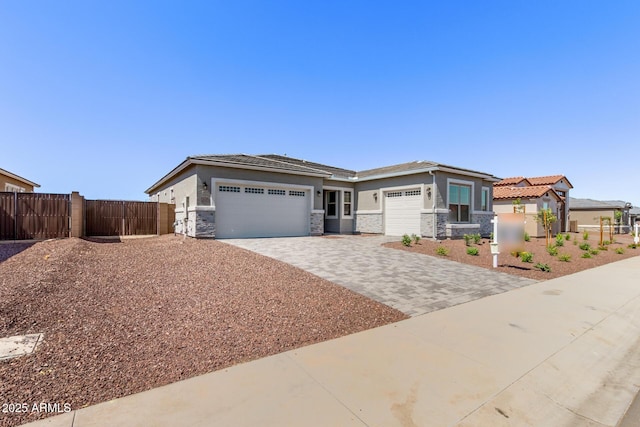 20274 W Monterey Way, Buckeye, AZ 85396 - prairie-style house with stone siding, an attached garage, decorative driveway, and stucco siding