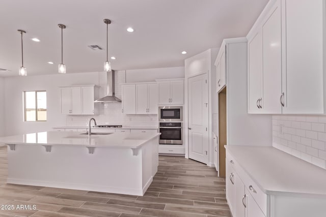 20274 W Monterey Way, Buckeye, AZ 85396 - kitchen with stainless steel oven, wall chimney range hood, black microwave, tasteful backsplash, and recessed lighting