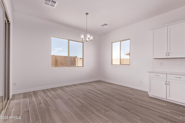 20274 W Monterey Way, Buckeye, AZ 85396 - unfurnished dining area with healthy amount of natural light, a chandelier, and light wood finished floors