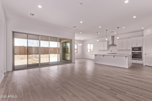 20274 W Monterey Way, Buckeye, AZ 85396 - unfurnished living room with light wood-style flooring and recessed lighting
