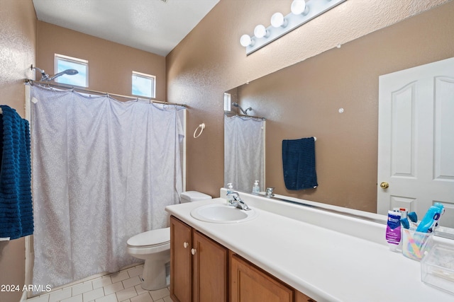 bathroom with toilet, vanity, a textured ceiling, and tile patterned flooring