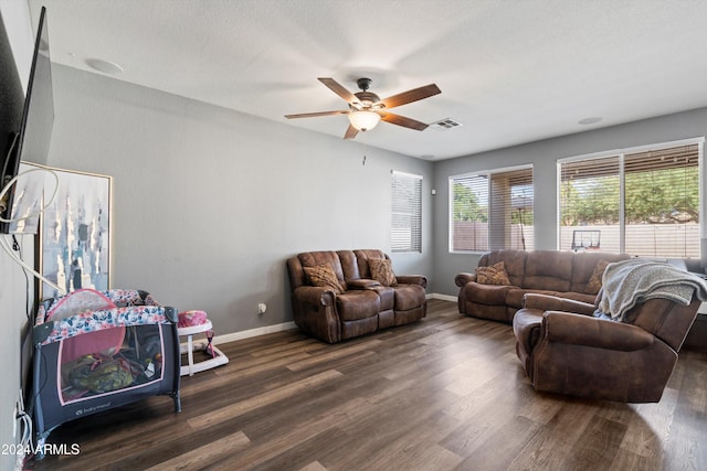 living room featuring a textured ceiling, dark hardwood / wood-style floors, and ceiling fan