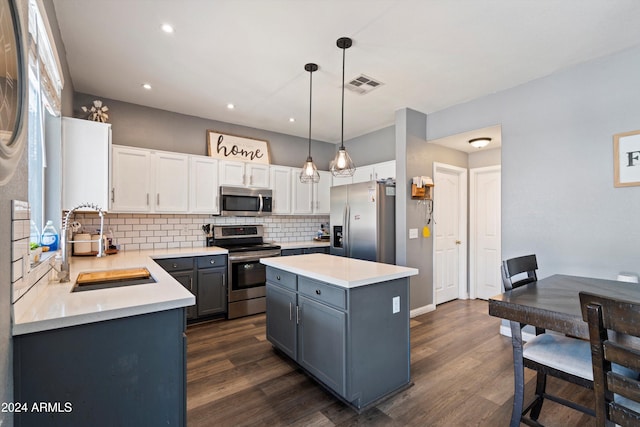 kitchen featuring white cabinetry, stainless steel appliances, dark hardwood / wood-style floors, and decorative light fixtures