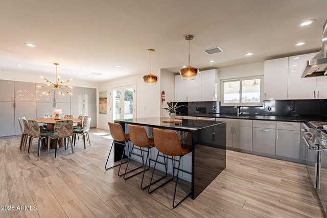 1911 E Claremont St, Phoenix, AZ 85016 - kitchen featuring a breakfast bar area, visible vents, dark countertops, modern cabinets, and a notable chandelier