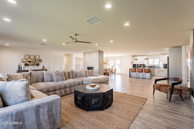 1911 E Claremont St, Phoenix, AZ 85016 - living area featuring recessed lighting, visible vents, light wood-style flooring, and ceiling fan with notable chandelier