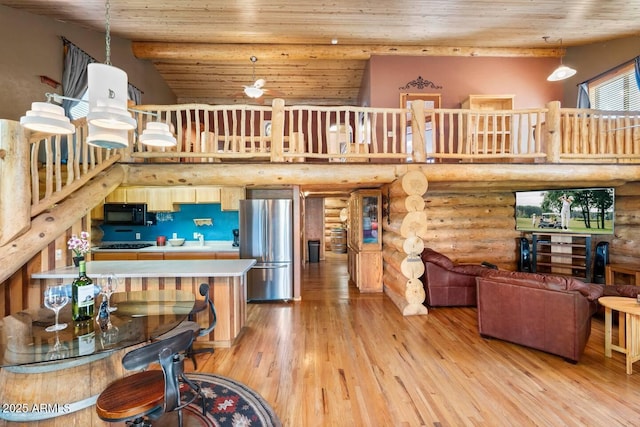 living area featuring light wood-type flooring, rustic walls, a towering ceiling, and wooden ceiling
