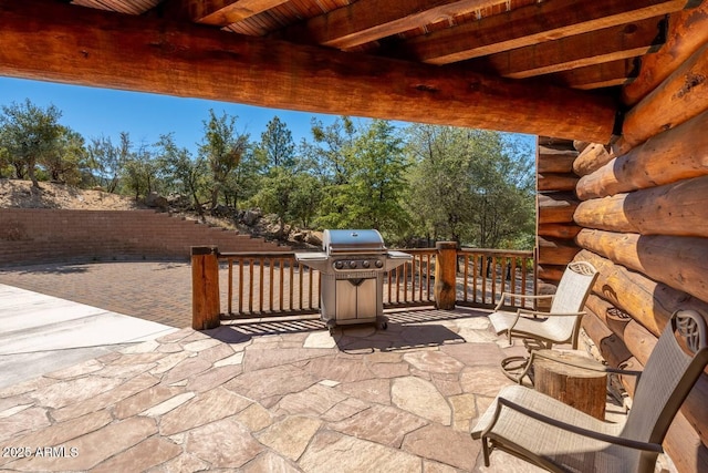 view of patio featuring a grill and fence