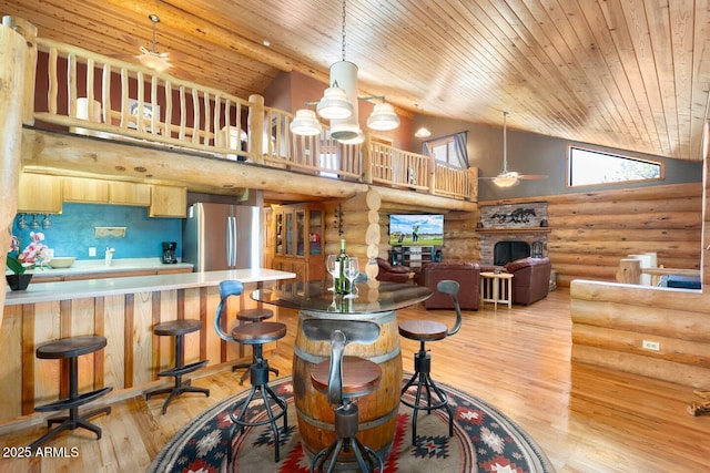 bar featuring rustic walls, freestanding refrigerator, high vaulted ceiling, and wood ceiling