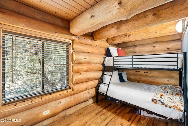 unfurnished bedroom featuring wooden ceiling, rustic walls, and wood finished floors