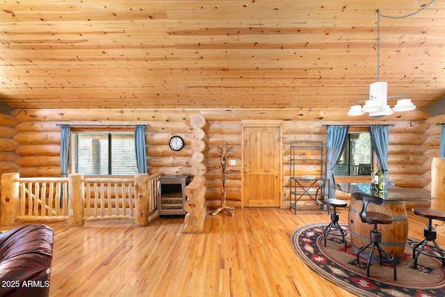 living area featuring light wood-style flooring, a wealth of natural light, log walls, and wood ceiling
