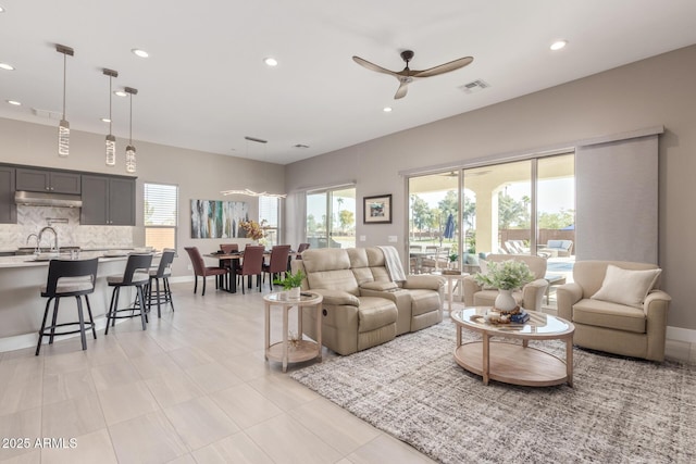 living room featuring ceiling fan and sink