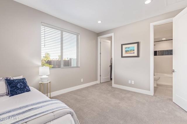 bedroom with connected bathroom and light carpet