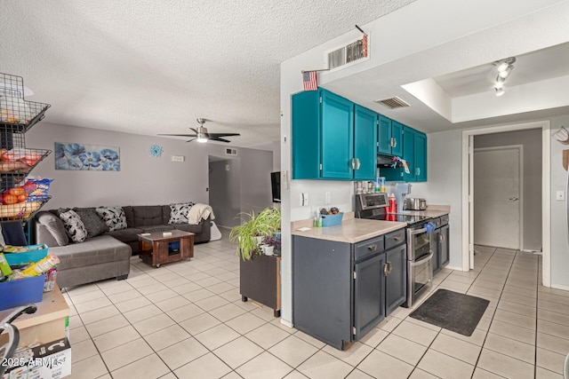 kitchen featuring ceiling fan, light tile patterned floors, visible vents, double oven range, and light countertops