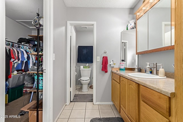 bathroom with visible vents, toilet, a textured ceiling, vanity, and tile patterned flooring