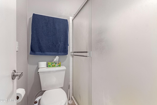 bathroom with toilet and a stall shower