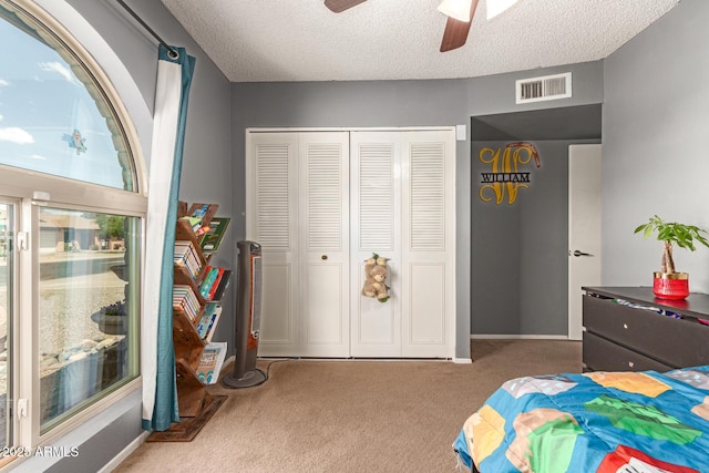 bedroom with a textured ceiling, a closet, carpet flooring, and visible vents