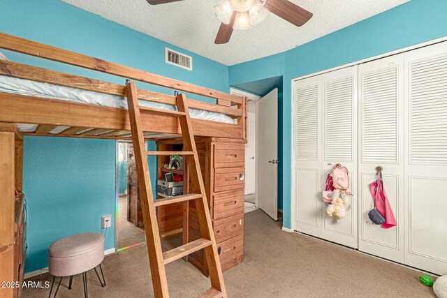 bedroom featuring ceiling fan, carpet, a textured ceiling, a closet, and visible vents