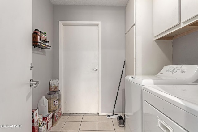 laundry area featuring independent washer and dryer, a textured ceiling, light tile patterned floors, and cabinet space