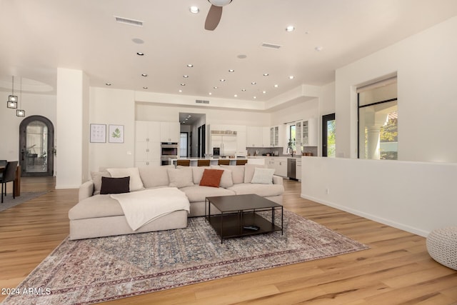 living room featuring ceiling fan and light hardwood / wood-style flooring