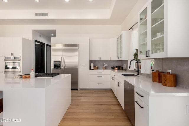 kitchen with appliances with stainless steel finishes, sink, and white cabinets