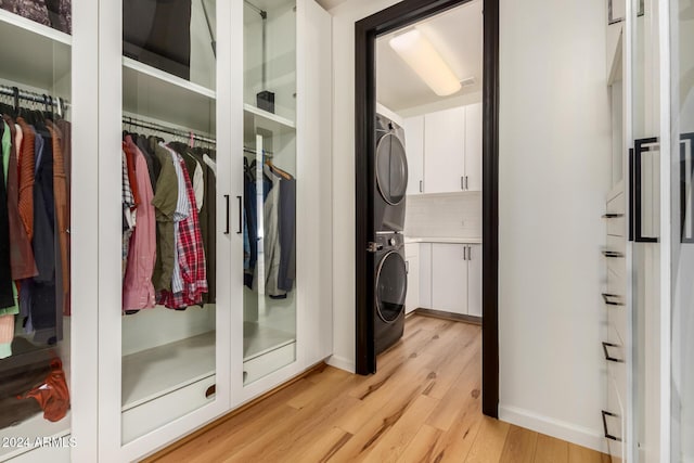 interior space with stacked washer and clothes dryer and light hardwood / wood-style floors