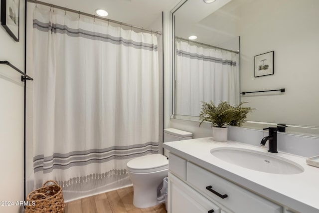 full bathroom with vanity, hardwood / wood-style floors, shower / bath combo, and toilet