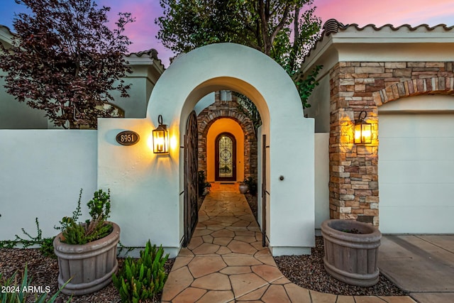 exterior entry at dusk with a garage