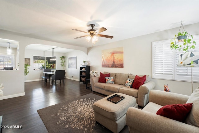 living room with ceiling fan and dark hardwood / wood-style flooring