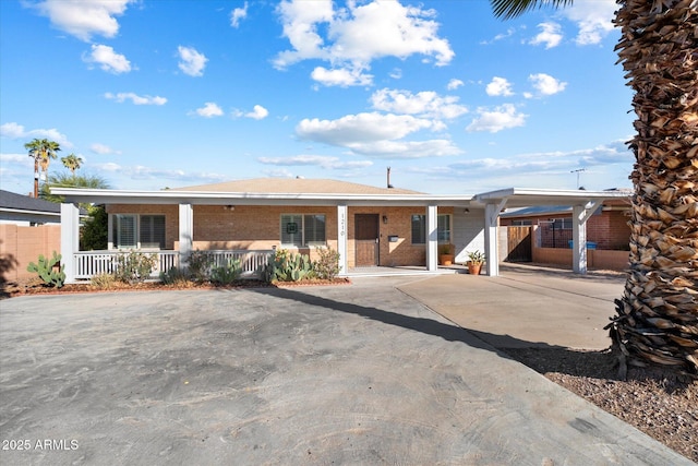 ranch-style home with covered porch and a carport