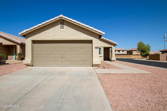 view of front of property featuring a tiled roof, stucco siding, driveway, and a garage