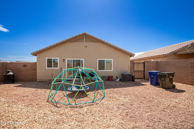 back of house with stucco siding, cooling unit, and a fenced backyard