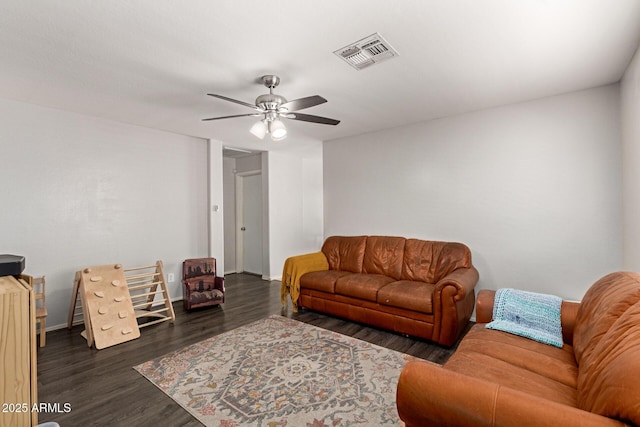 living room with visible vents, baseboards, wood finished floors, and a ceiling fan